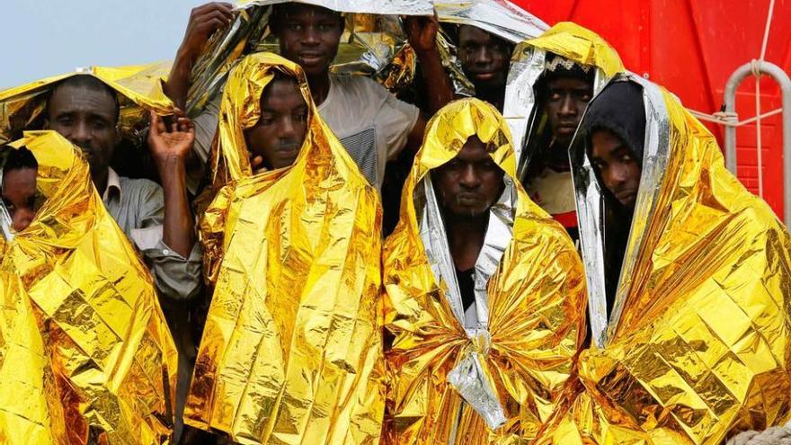 Inmigrantes rescatados en alta mar, a su llegada al puerto siciliano de Mesina.