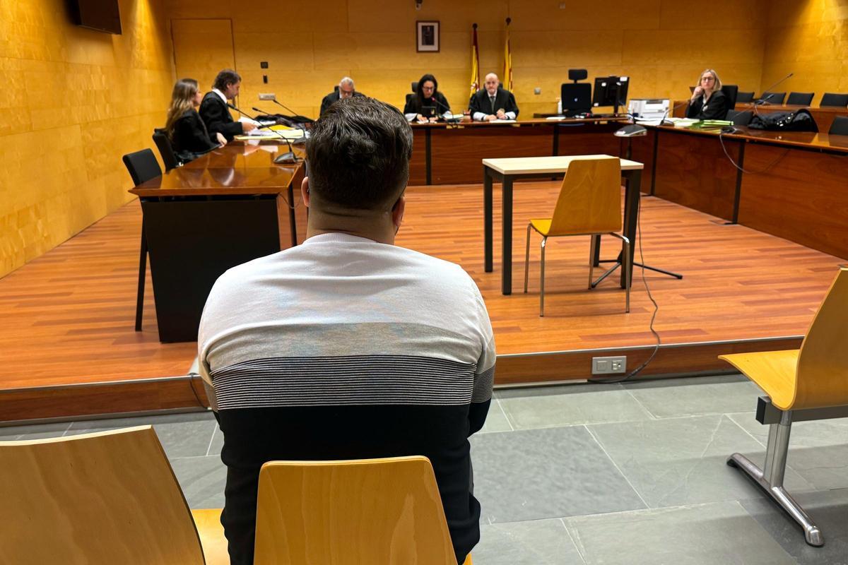 D'esquenes, l'acusat d'abusar sexualment d'una menor a la Bisbal d'Empordà. Foto del judici a l'Audiència de Girona