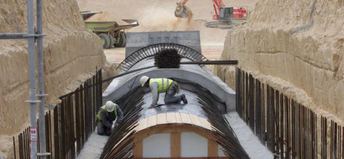 Una pareja de operarios trabaja en las canalizaciones del postrasvase Júcar-Vinalopó en Elche, cuya gestión será de la Junta Central de Usuarios.