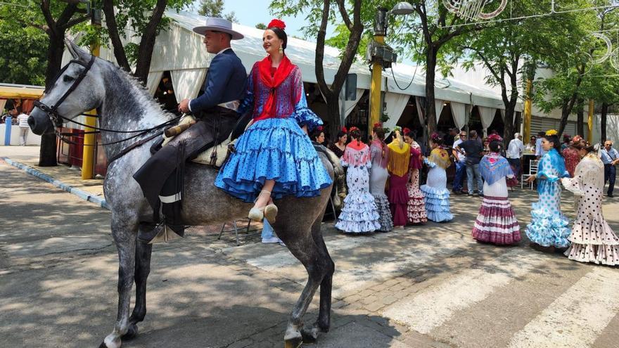 Un caballista, con su acompañante, pasea por el recinto ferial de Palma del Río.