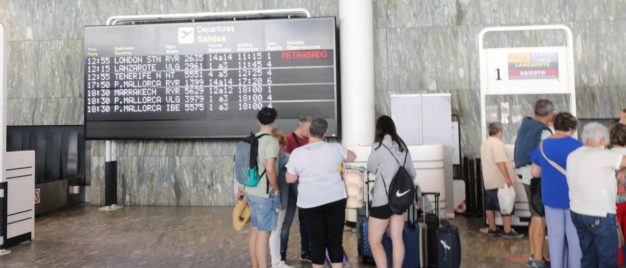 Un grupo, esperando ayer delante del panel informativo con las salidas previstas desde el aeropuerto de Zaragoza. | ÁNGEL DE CASTRO