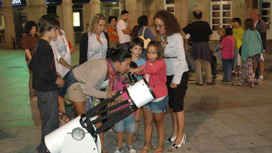 Una mujer observa la Luna en el centro de Porriño.  // J. Cardoso (D.P.)