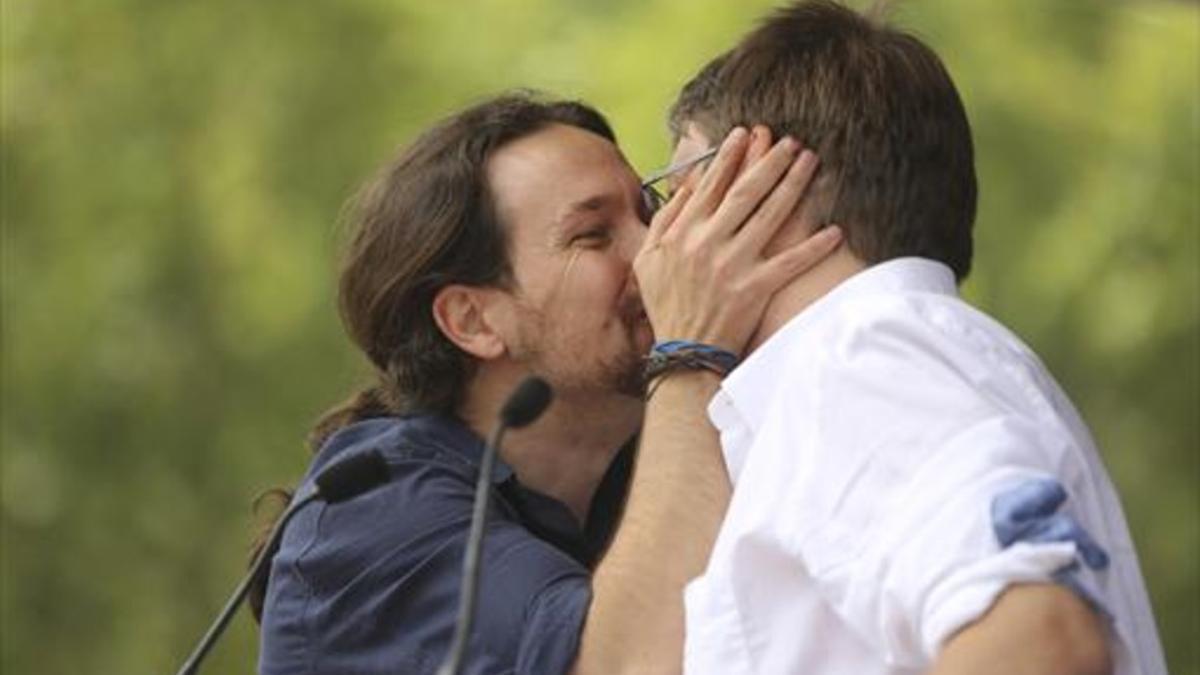 Pablo Iglesias besa en la boca a Xavier Domènech durante el acto de En Comú Podem en Barcelona.
