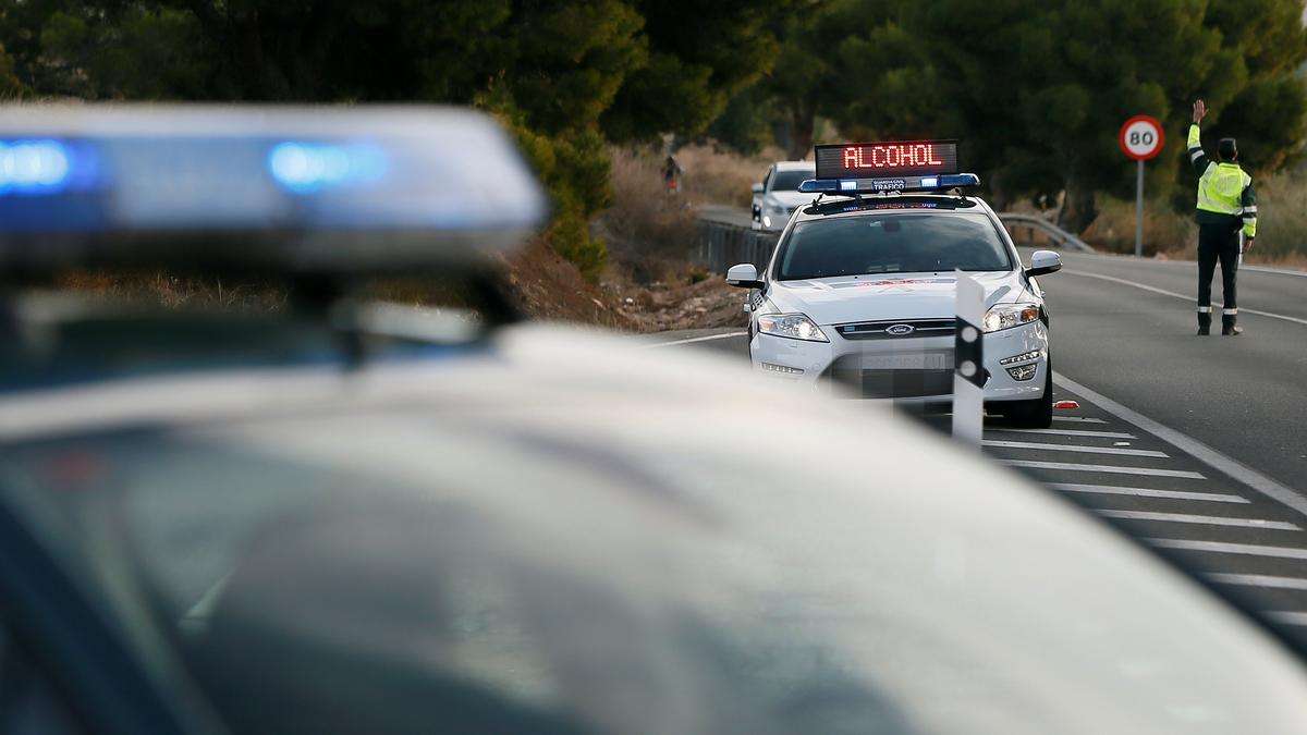 Un agente de la Guardia Civil da el alto a un vehículo en un control de tráfico.