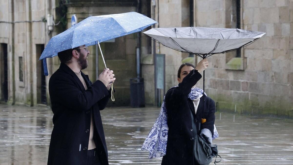 Una pareja de jóvenes durante un día lluvia en la praza do Obradoiro, en Santiago