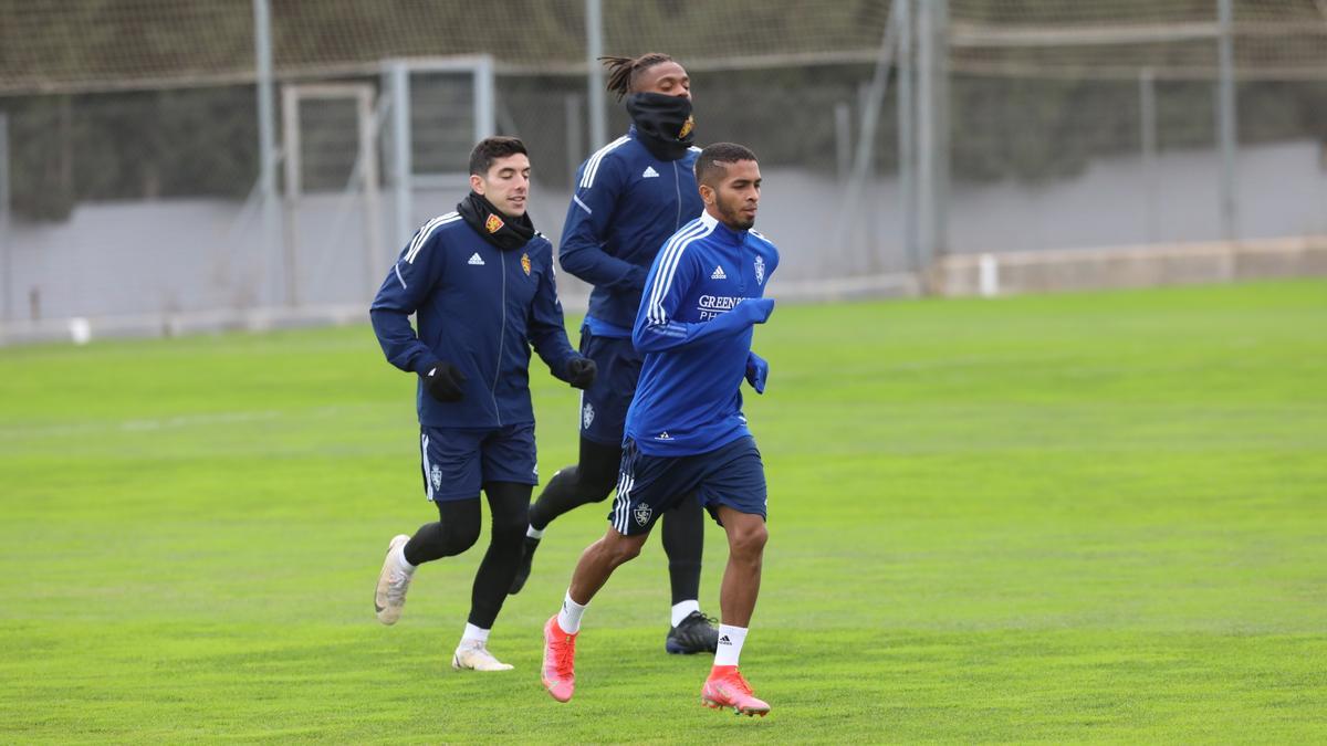 César Yanis corre por delante de Jair y Fran Gámez en un entrenamiento del Real Zaragoza.