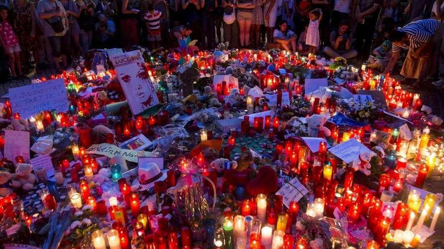 Personas congregadas anoche en las Ramblas en torno a velas y flores. // Efe