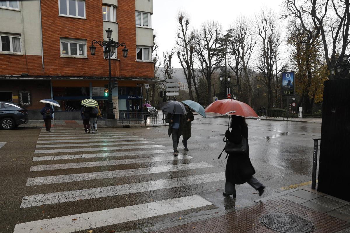 Viandantes con paraguas, este viernes, por Oviedo.