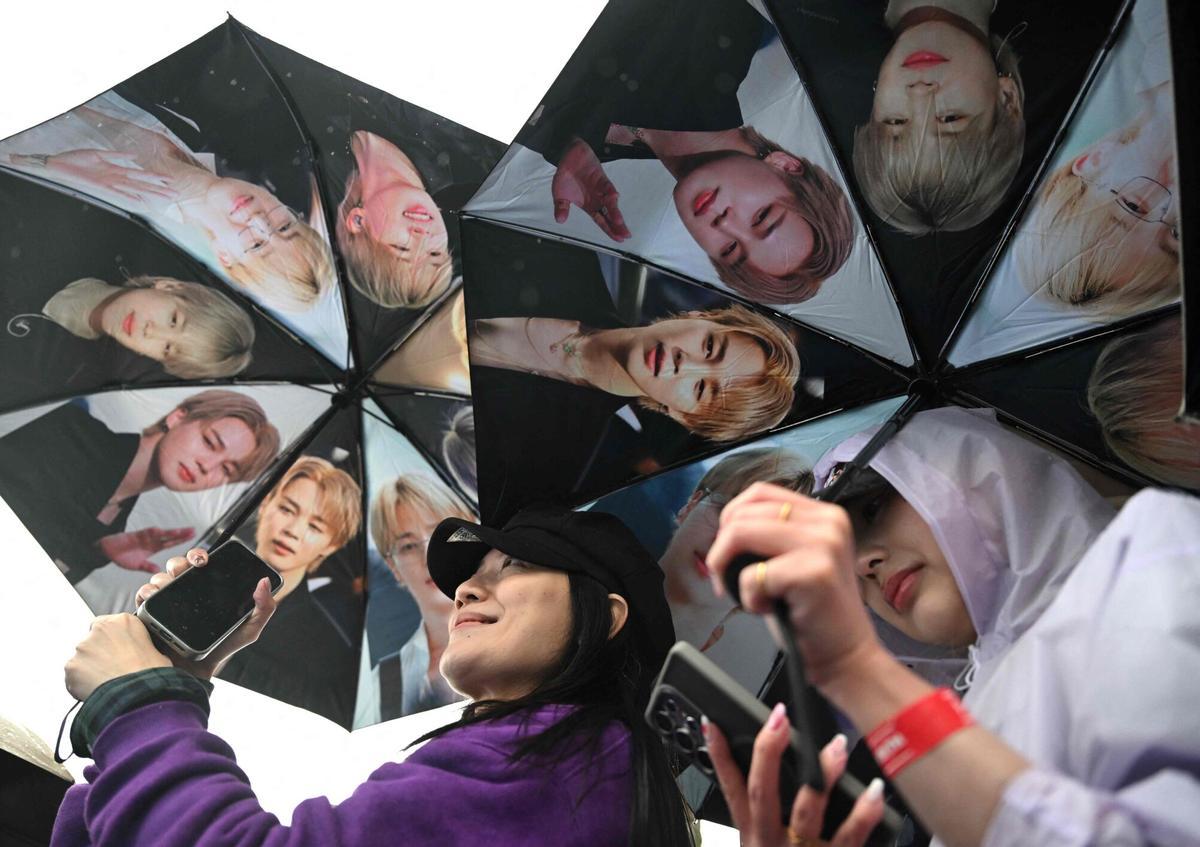 Los fans de BTS portan paraguas con la imagen de los miembros del grupo de K-pop BTS a su llegada al estadio donde el grupo actuará en Goyang el 9 de abril de 2026. Las megaestrellas surcoreanas del K-pop, BTS, dieron inicio a su gira mundial el 9 de abril, aprovechando el éxito de su álbum de regreso, que alcanzó la cima de las listas, y una actuación histórica en el corazón de Seúl. (Foto de Jung Yeon-je / AFP)