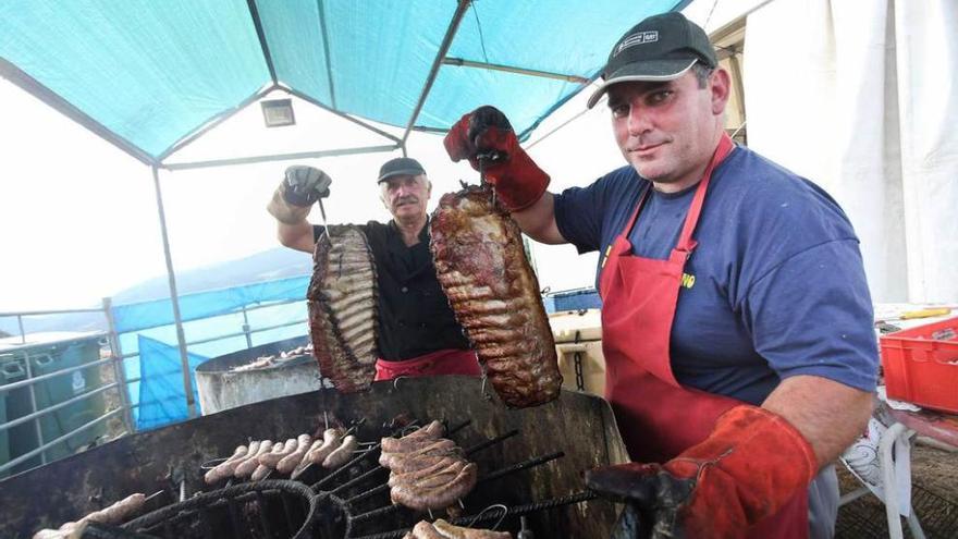 Por la izquierda, los parrilleros Víctor Fernández y Pablo Álvarez muestran orgullosos sendos costillares.