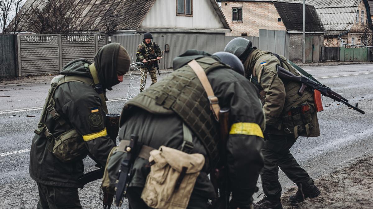 Varios soldados del ejército ucraniano colocan una alambrada.