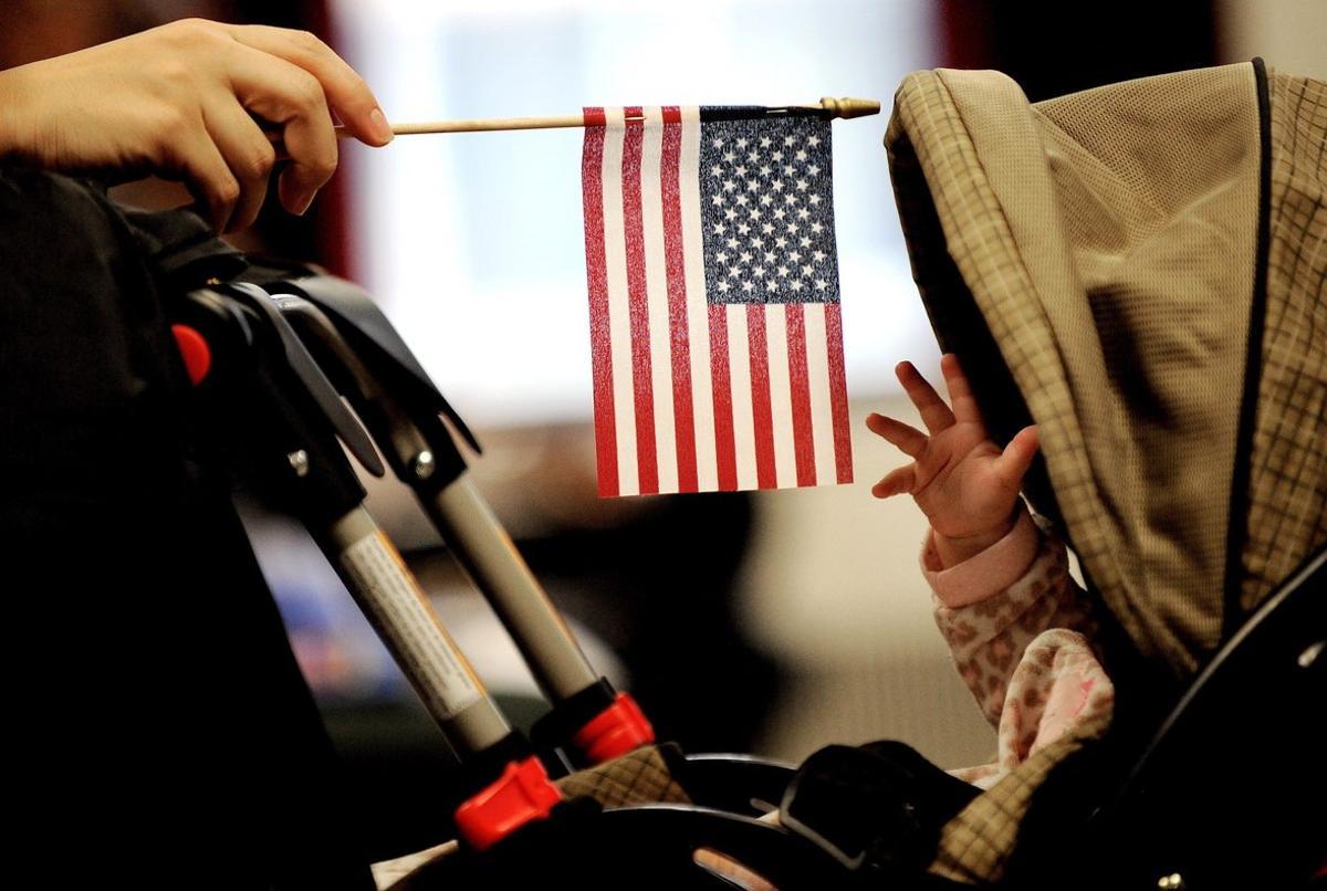 JLX03  NUEVA YORK  ESTADOS UNIDOS   31 10 2018 - Imagen de archivo que muestra a un bebe que intenta alcanzar la bandera estadounidense que sostiene su madre en Nueva York  Estados Unidos  el 14 de enero de 2011  El presidente de Estados Unidos  Donald Trump  aseguro ayer  30 de octubre de 2018  que quiere poner fin al derecho a la ciudadania para los nacidos en el pais  lo que ha suscitado numerosas criticas y supone un aumento de su tono antiinmigracion  en medio de la campana de las elecciones legislativas del 6 de noviembre  EFE  Justin Lane