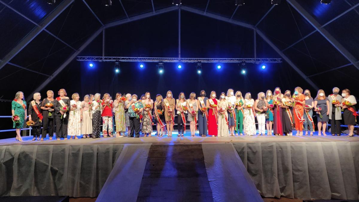 Foto de familia de todas las damas subidas sobre el escenario de la carpa de fiestas del puerto.