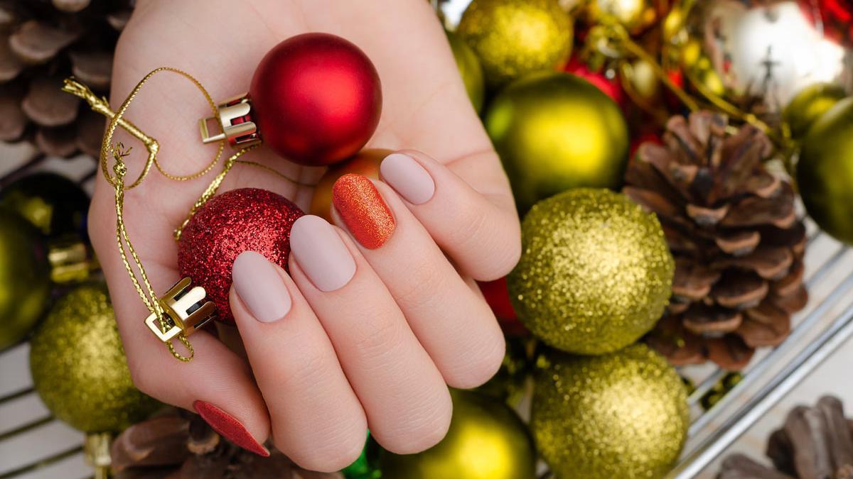 Propuestas de manicura de Navidad, con uñas nude y rojas 'shimmery'