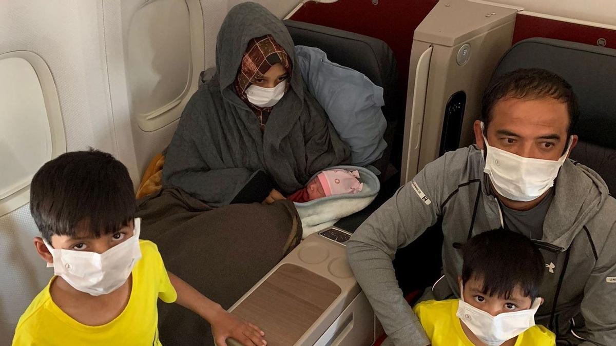 Afghan family with their newborn baby sit on board an evacuation flight to Birmingham