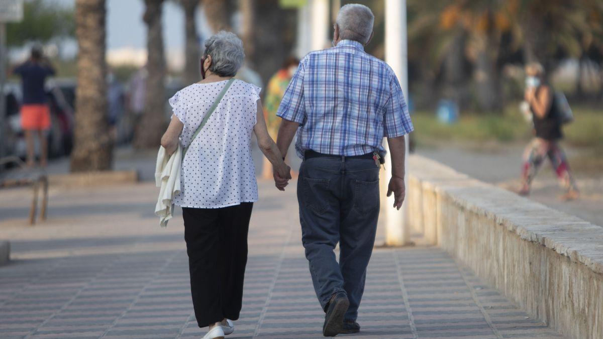 Una pareja de jubilados en un paseo marítimo.