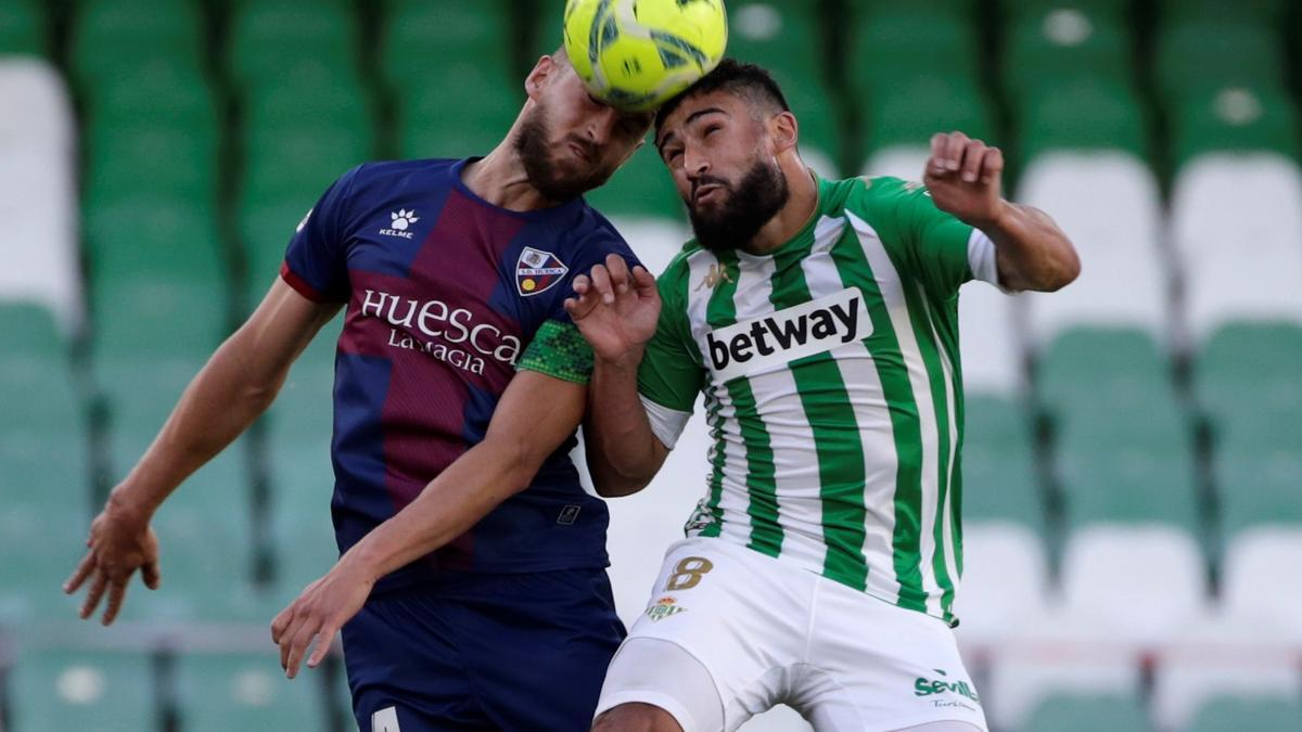 Pugna entre Pulido y Fekir en un balón aéreo durante el partido del Huesca en Sevilla.