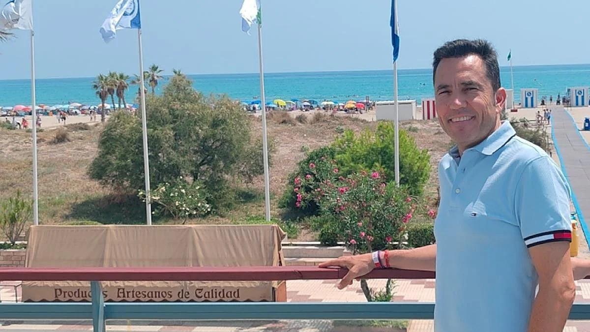 El alcalde en la playa junto a las banderas.