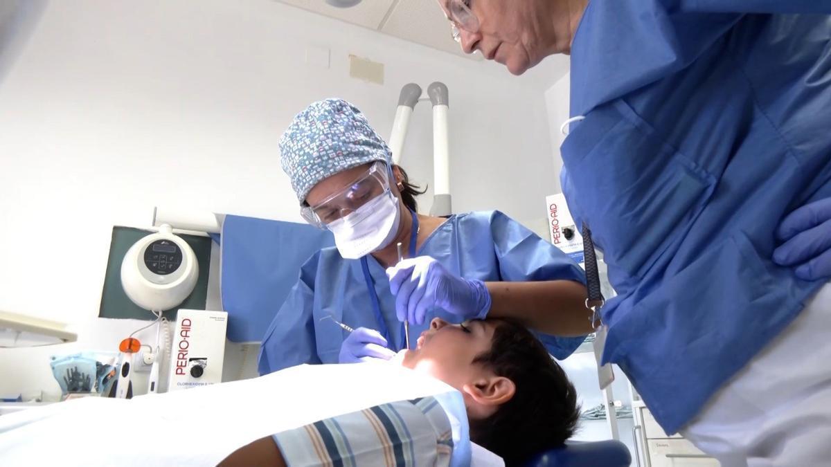 Una dentista atiende a un paciente.