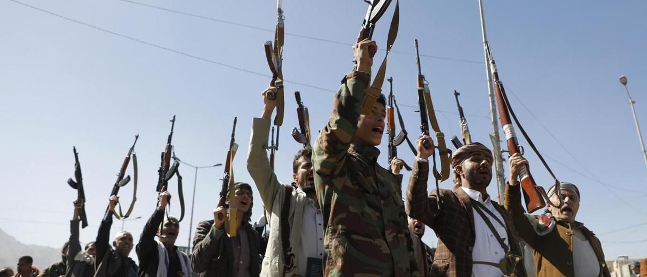 Combatientes hutíes recién reclutados alzan sus armas y cantan eslóganes al final de uno de sus entrenamientos en Saná, Yemen