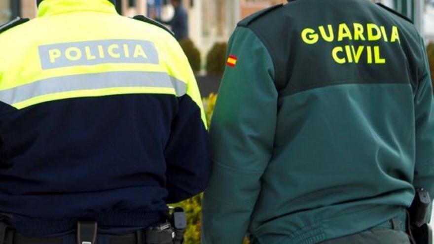 Un policía local y un guardia civil, de espaldas.