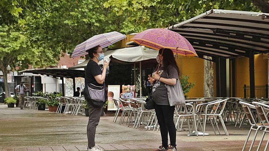 Dues dones durant un episodi de pluja al Passeig Pere III de Manresa