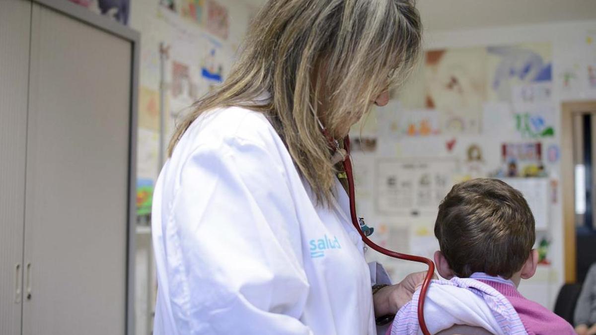 Una pediatra atiende a un niño en su consulta.