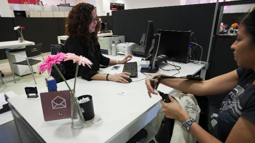 Una empleada del Ayuntamiento de Santa Cruz atiende a una ciudadana en las dependencias municipales de La Granja.