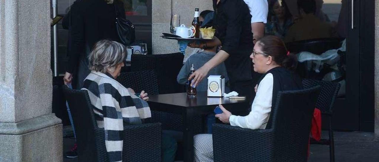 Una camarera atiende una mesa en un local de Pontevedra. // Rafa Vázquez