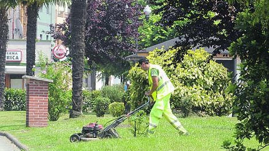 Un operario corta el césped en el parque de La Laguna