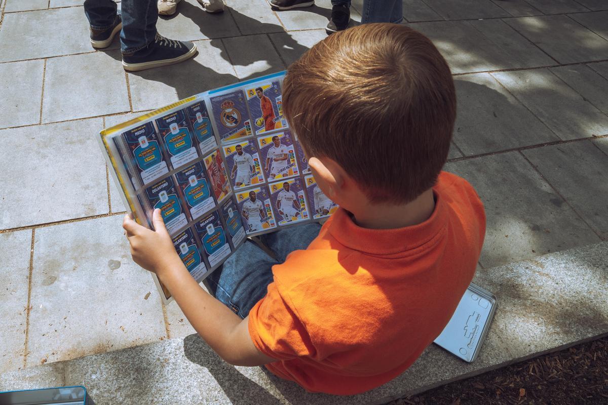 Un niño mira su álbum de cromos. 