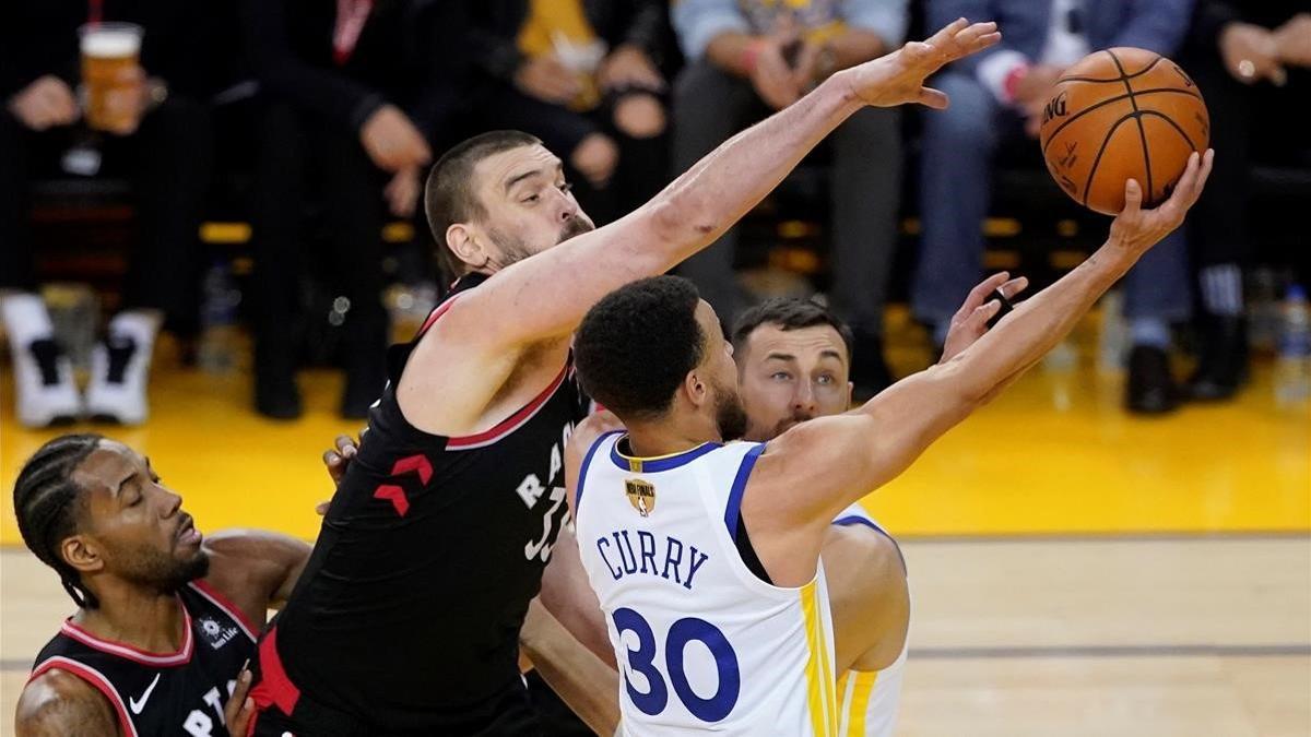 Gasol trata de taponar una acción de Curry.