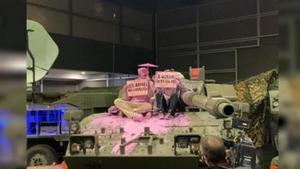 Protesta por la presencia del Ejército en Expojove con el vertido de pintura sobre un tanque