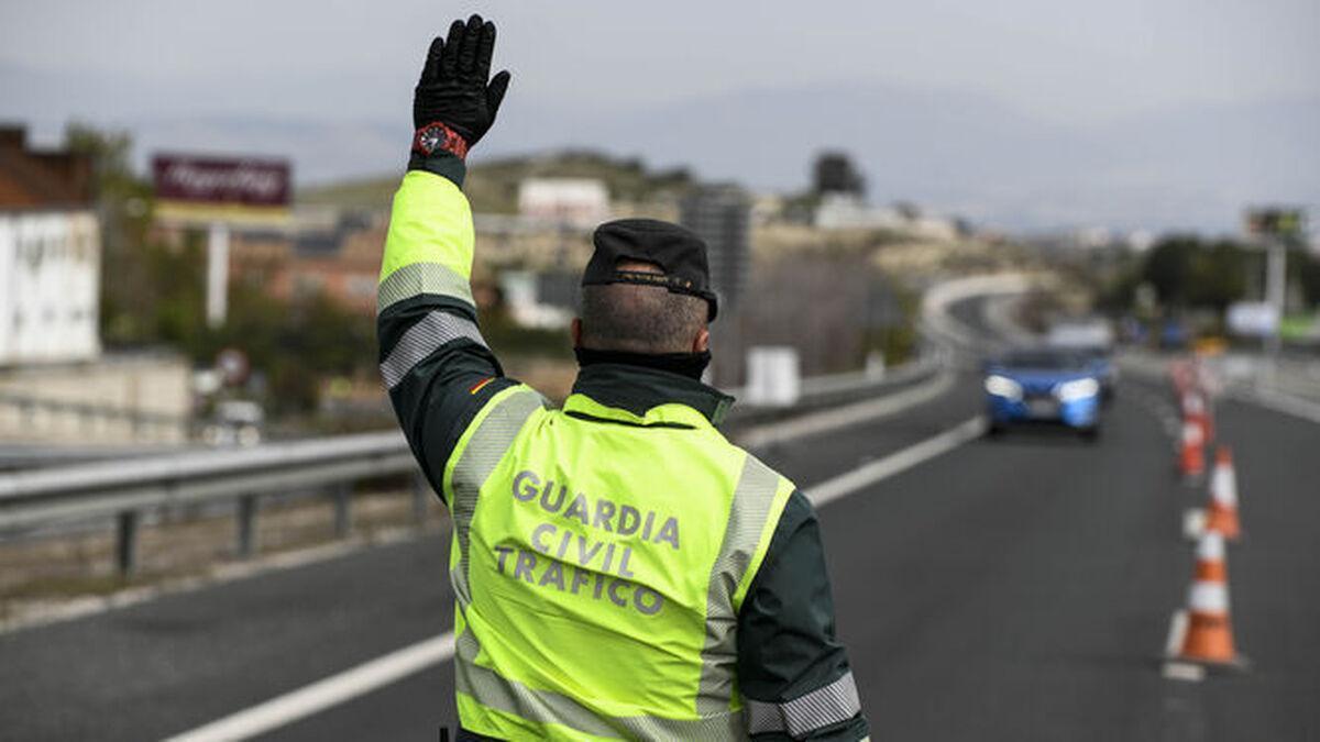 Un agente de la Guardia Civil de Tráfico manda parar a un vehículo en carretera.