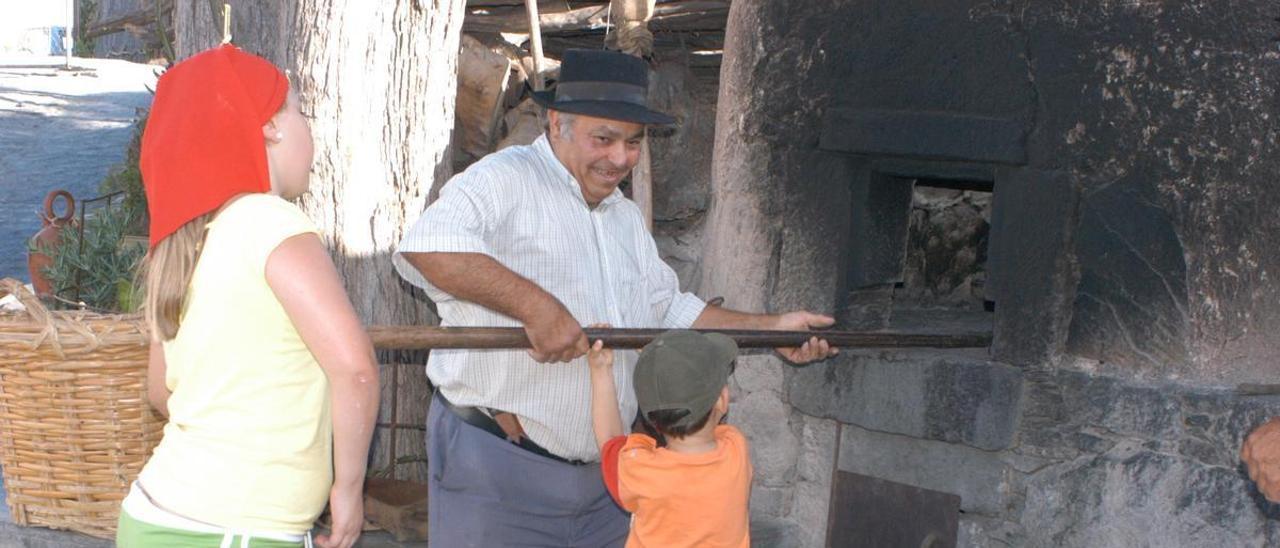 Juanito enseña a niños de La Aldea a elaborar pan en un horno de leña