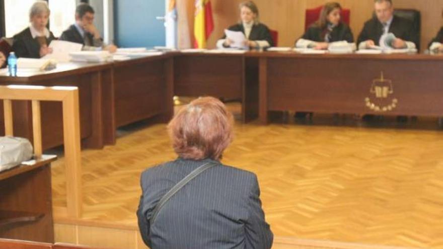 La acusada, de espaldas, ayer en el banquillo de la Audiencia viguesa.  // Jesús de Arcos