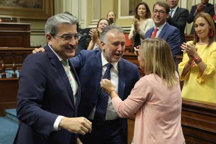 GRAFCAN5194. SANTA CRUZ DE TENERIFE, 12/07/2019.- Los portavoces de los grupos de Nueva Canarias, Román Rodríguez (i), y de Si Podemos Canarias, Noemí Santana, felicitan al socialista Ángel Víctor Torres, tras ser elegido presidente de Canarias al término del debate del pleno de investidura. EFE/ Cristóbal García