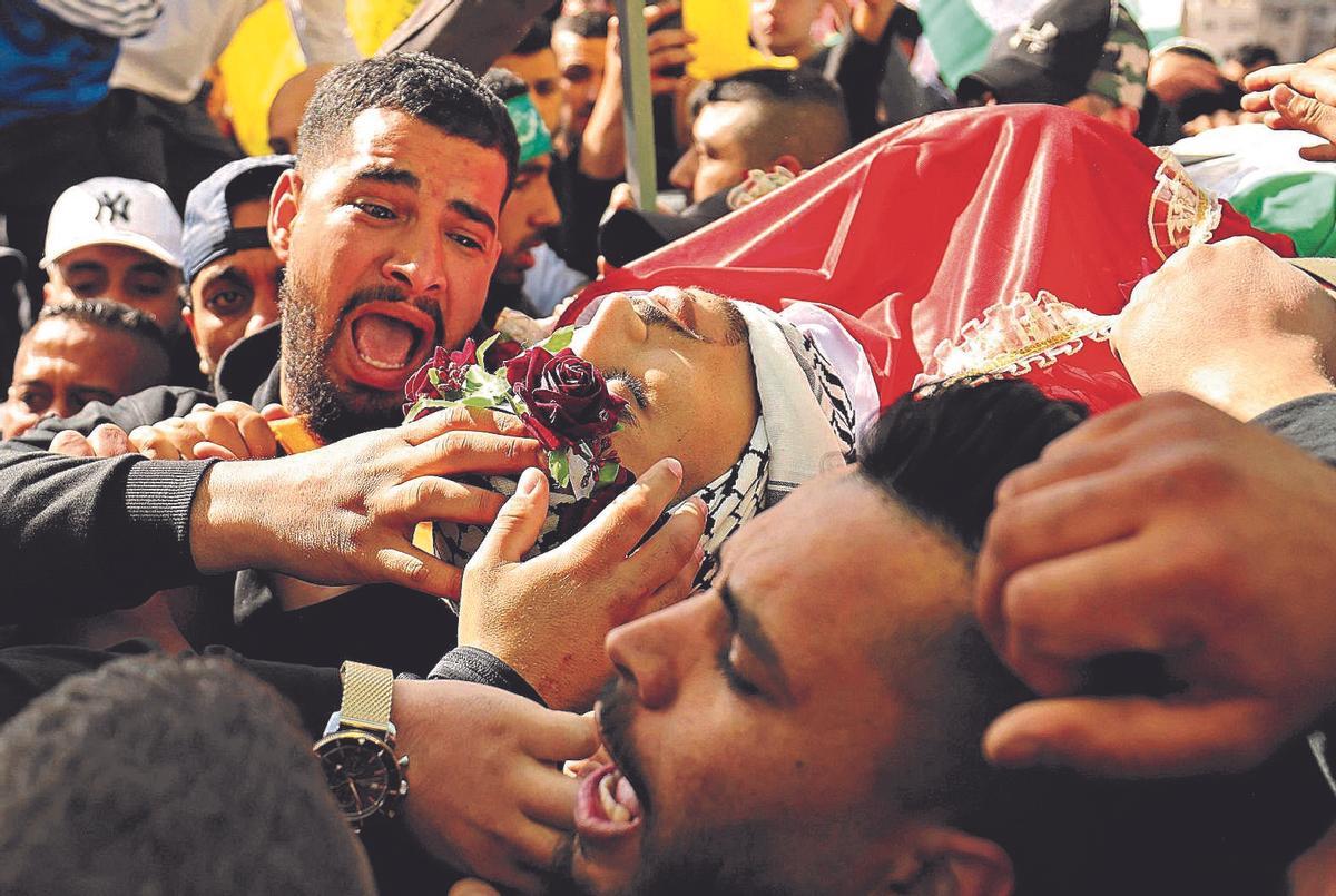 Un grupo de palestinos llora durante el traslado de una de las víctimas mortales de un ataque israelí­ en Yení­n