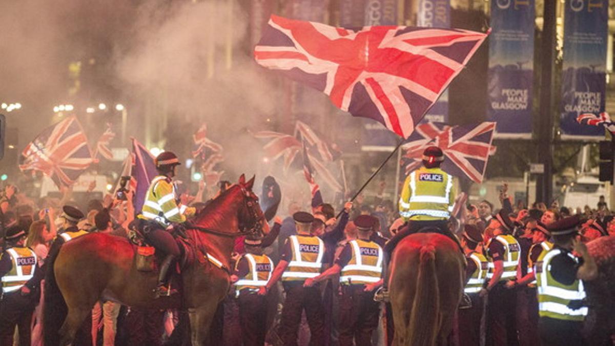 Agentes de policía intervienen en los desórdenes registrados anoche en Glasgow.