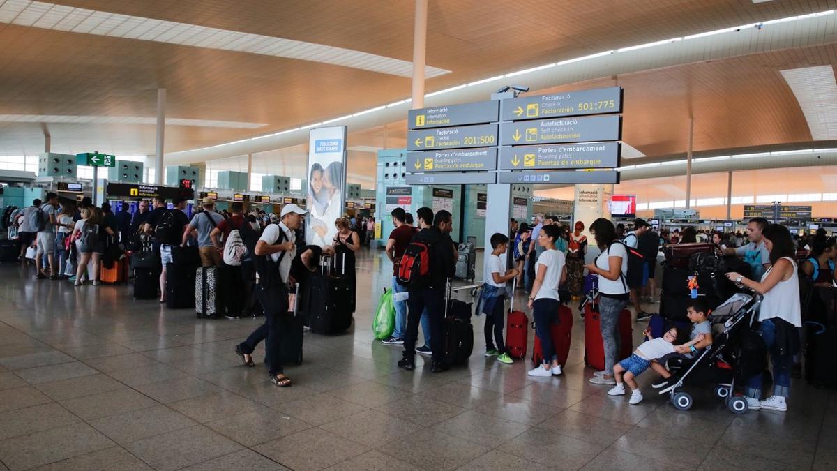 Colas de pasajeros esperando para facturar en el aeropuerto de El Prat.