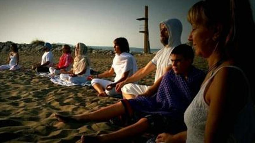 Un grup de persones practicant ioga a la platja de Sant Martí d&#039;Empúries