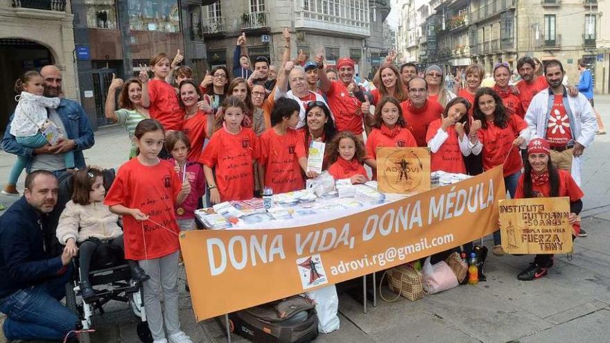 Integrantes de Adrovi y Asampo posan junto al stand situado ayer en la Praza da Peregrina. // Rafa Vázquez