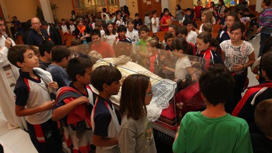 Escolares del Colegio Don Bosco de Alicante ante la estatua yacente del «Padre, maestro y amigo de los jóvenes».