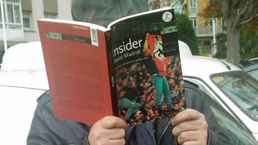 David Madrid oculta el rostro con un ejemplar del libro ´Insider´, en el que narra su experiencia tras un año y medio infiltrado