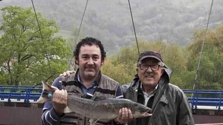 José Luis González, con gafas, con su hijo sujetando el salmón que sacó en el Cares.