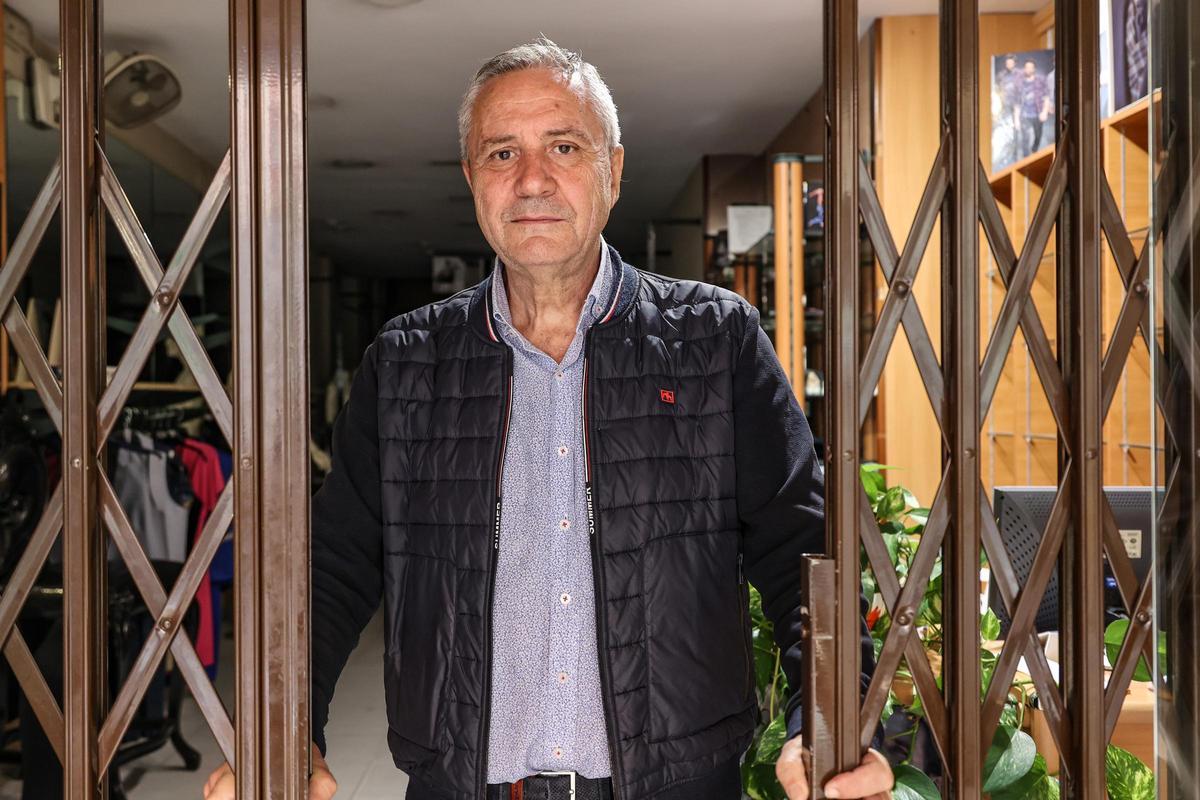 Rafa Pérez detrás de la persiana de su comercio en Alcoy, que ha tenido que cerrar por jubilación.