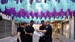 Bombers de Barcelona inspeccionan las calles engalanadas de Gràcia para garantizar la seguridad.