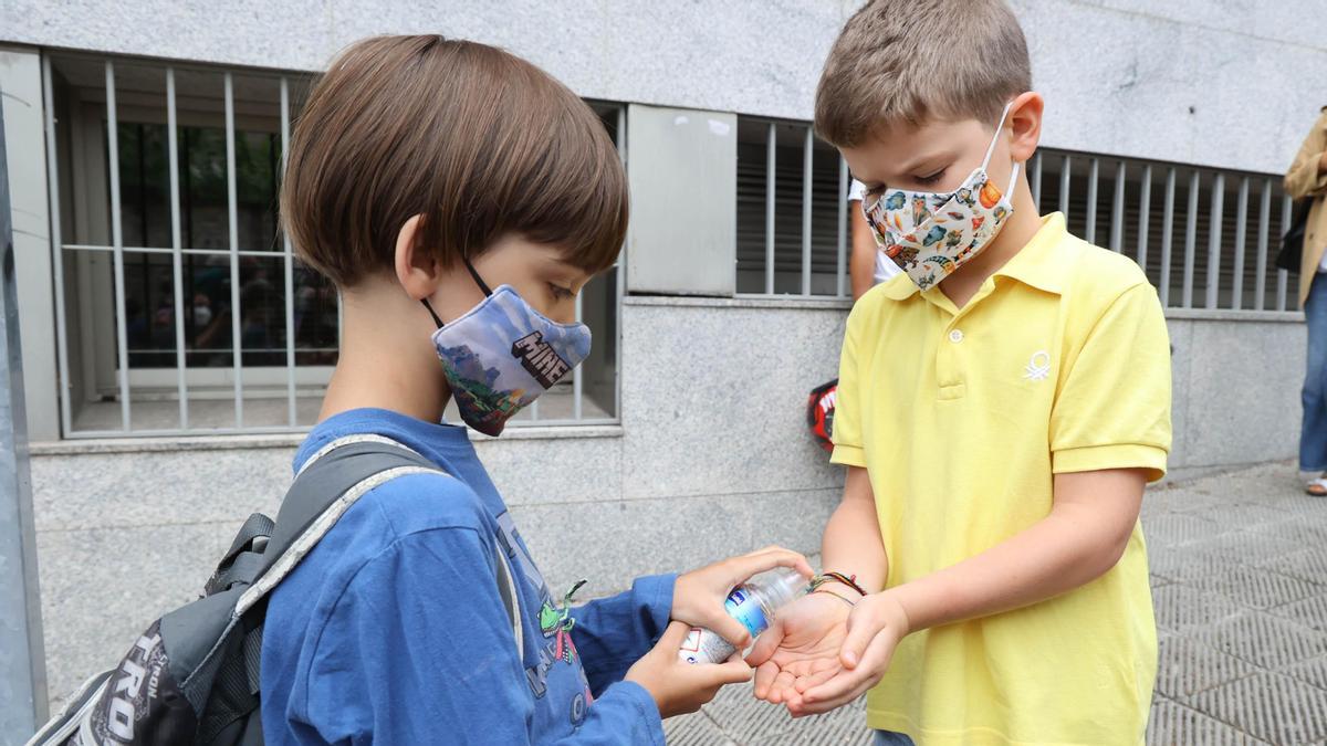 Un niño le echa gel hidroalcohólico a otro en el colegio Doutor Fleming