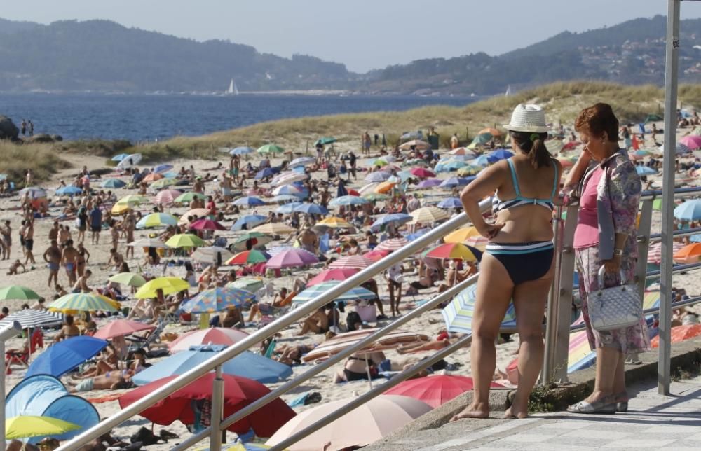 El buen tiempo anima a los bañistas en la playa de Samil