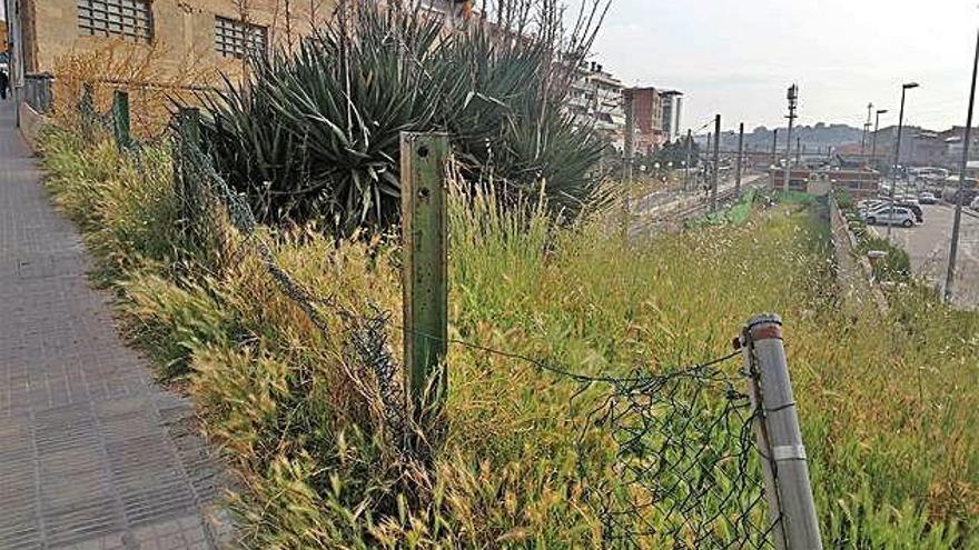 Una tanca malmesa sobre la via del tren que és un perill